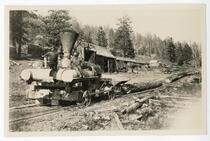 Loggers astride machinery for hauling logs, California
