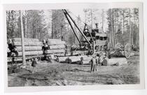 Loggers loading logs onto railroad cars