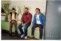 Three people sitting on a bench at the California Flower Market
