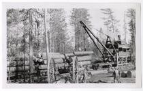 Loggers loading logs onto railroad cars