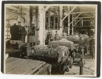 Men standing at the filter presses used for processing beet sugar, California 