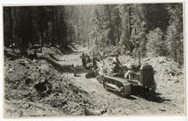 Man on tractor pulling road plow, California