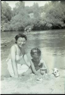 Woman and child at a river beach