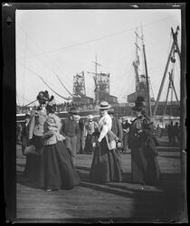 Spectators on pier, including Red Cross volunteer, as troops board ship, San Francisco Bay