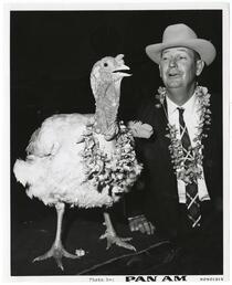Man and turkey wearing leis, April 20, 1966