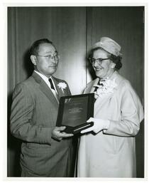 Man and woman holding a Charles J. Lane memorial plaque