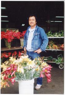 Portrait of man in denim posing with floral display