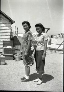 Two women posed outside, clothes line in background