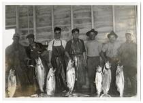 Fishermen holding a sample of the six tons of salmon caught