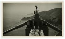 Golden Gate Bridge construction, man waving atop completed north tower
